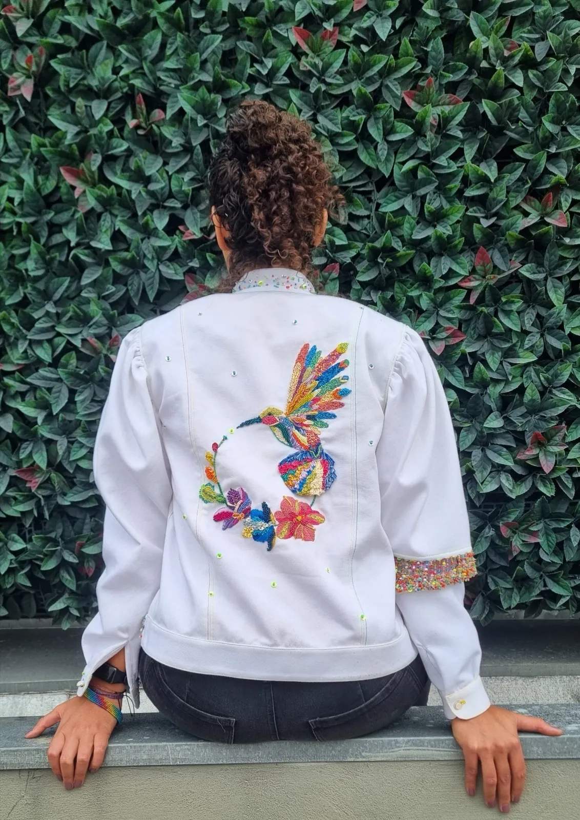 Espalda de la chaqueta blanca con el colibrí bordado