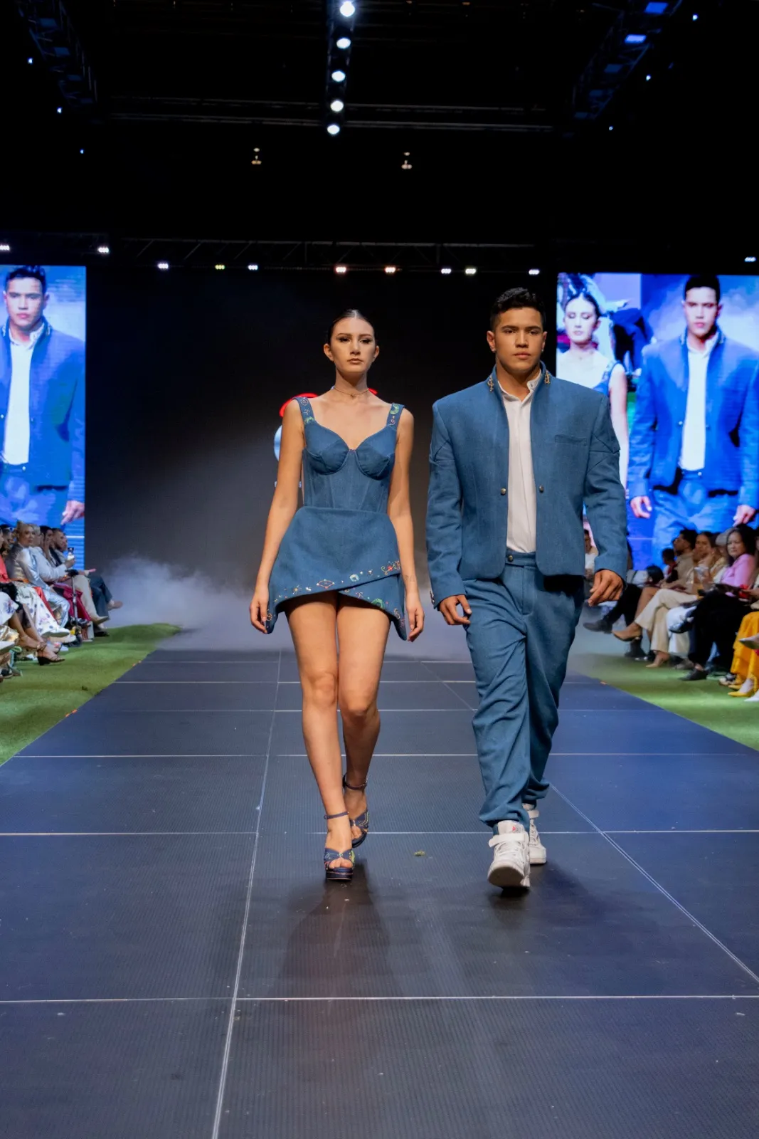 Dos modelos con piezas de denim caminando en pasarela