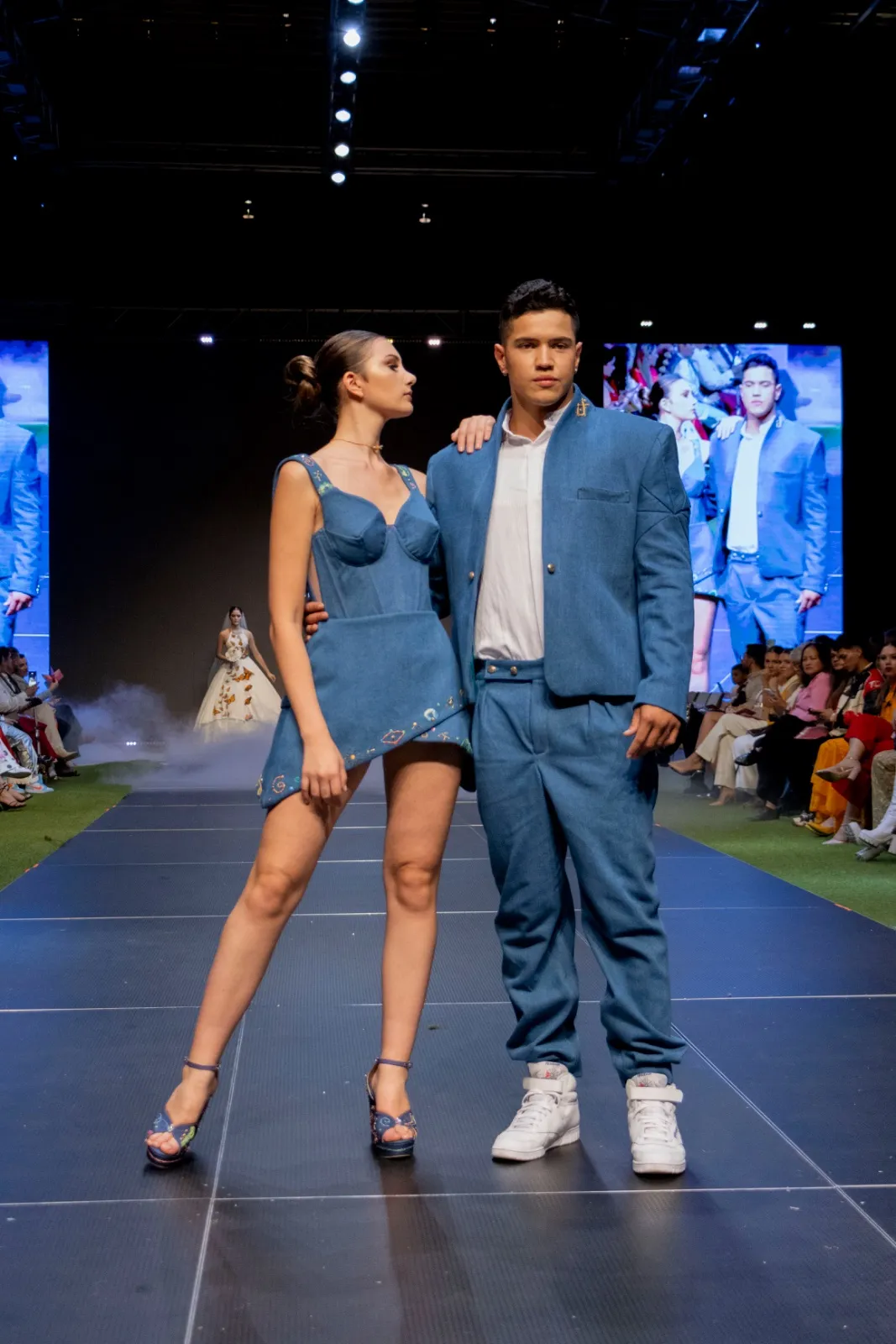 Dos modelos con piezas de denim posando en pasarela